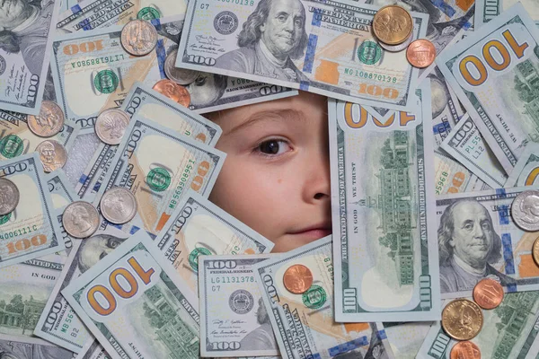 Money and banking. Money win, big luck. Funny child with fun face with money. Kid peeking out of dollar bills with astonished shocked eyes. Money background