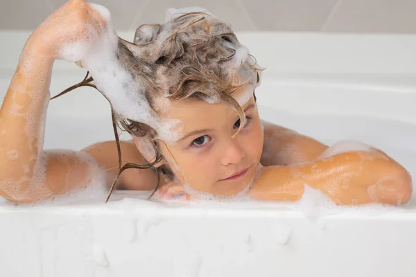 Kids bathing. Child in the bath with bubbles. Happy child enjoying bath time. Little boy smiling in the bath with soap foam. Child bathes in a bath with foam