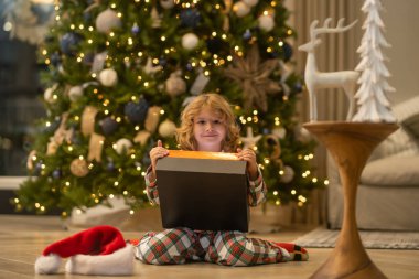 Noel 'i kutlayan küçük bir çocuk ya da evde Noel ağacı olan bir çocuk.