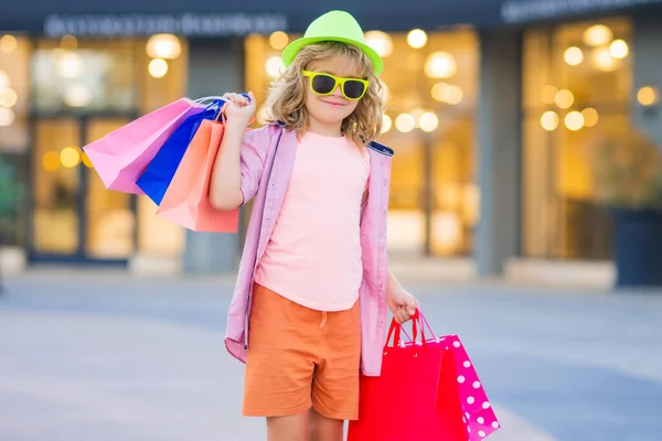 ファッションの子供は買い物に行く 屋外のショッピングパッケージの子供 商店街を歩いて買い物袋を持って買い物袋を持っている買い物客の子供 — ストック写真