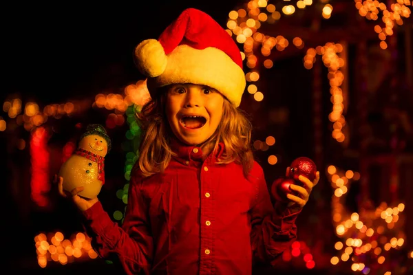 幸せな子供でサンタの帽子遊びの前に夜の家 — ストック写真