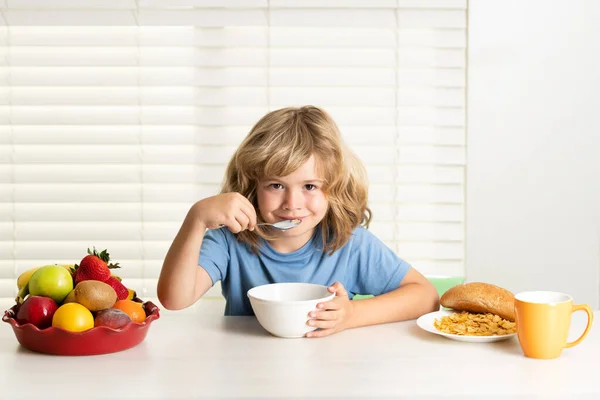 Kid preteen boy 7, 8, 9 years old eating healthy food vegetables. Breakfast with milk, fruits and vegetables. Child eating during lunch or dinner at home