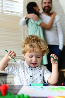 Çocuk sanatı, yaratıcılık, çocuk konsepti. Mutlu aile portresi çizimleri. Baba, anne ve çocuk bir evde bir araya gelirler. Çocuklar resim yapar