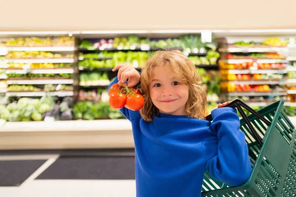 新鮮なトマト野菜の子供 スーパーで買い物 子供たちはスーパーで食料品を買う 小さな男の子は食料品店で新鮮な野菜を買う 子供は食べ物を買う — ストック写真