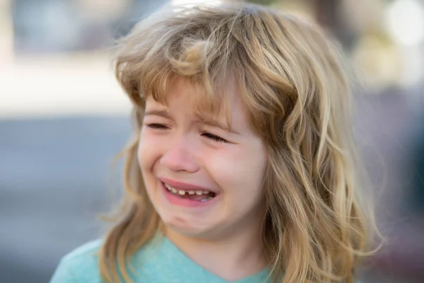 Portrait of crying kid with tears weeping emotion, hurt in pain. Tear drops on cheek