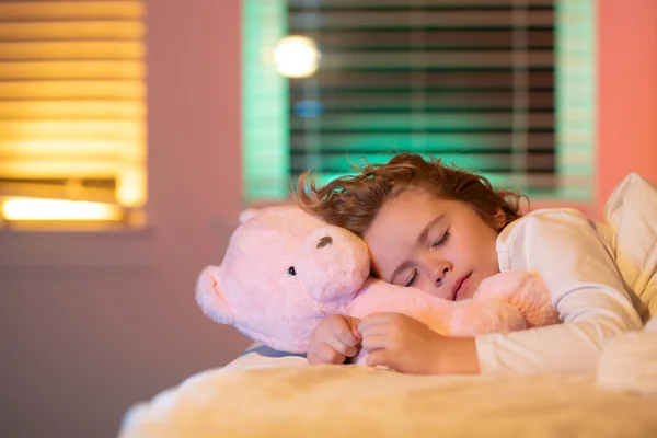 Sweet sleep. Kid sleeping with a toy teddy bear in bed. Child sleeping in bed under blanket. Kid lying on pillow, child rest asleep, enjoy healthy sleep or nap