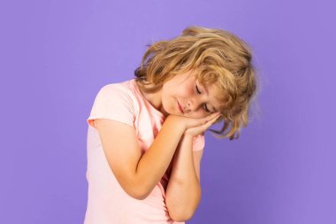 Uyuyan sarışın çocuk, izole edilmiş stüdyo arka planında rüya gören çocuk.