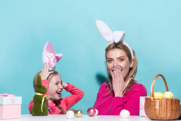 Mom with little cute girl are preparing for Easter. Mother and daughter wearing bunny ears are kissing. Easter banner, mockup copy space, poster flyer header for website template