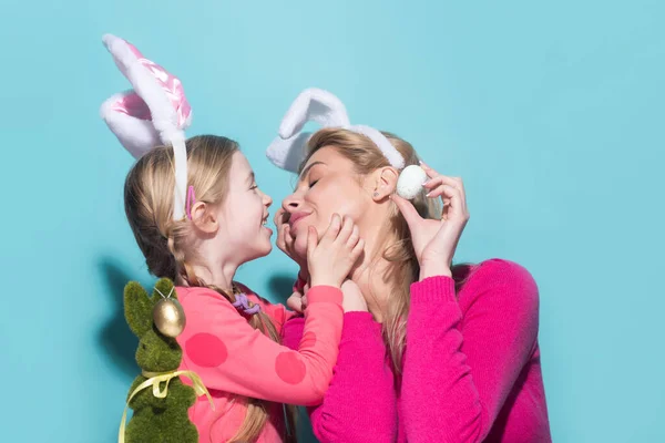 Family easter. Mom with daughter are preparing for Easter kissing. Mother and child wearing bunny ears. Easter banner, poster flyer header for website
