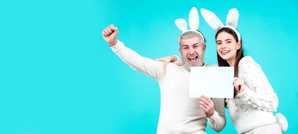 青い背景に隔離されたウサギの耳とウサギの衣装で興奮イースターカップル ウェブサイトのヘッダーデザインのためのワイドフォトバナー — ストック写真