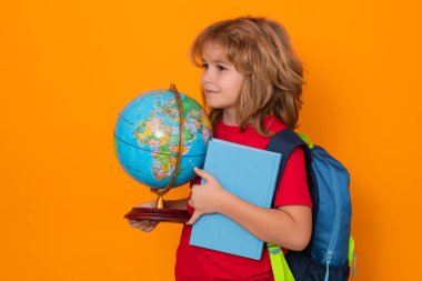 Okullu çocuk dünyayı ve kitabı elinde tutuyor. Okula dönelim. İlkokuldan elinde kitapla komik bir öğrenci. Stüdyoda izole edilmiş bir arka plan