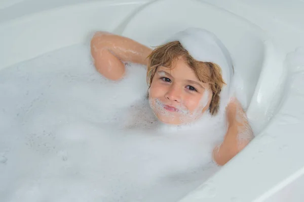 Children bathing. Kid bathing in a bath with foam. Funny kid face bathed in the bath