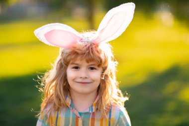 Tavşan çocuk suratı. Paskalya çocuğu parkta. Parkta tavşan kulaklı tavşan kostümlü çocuk.