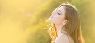Spring woman on sunlight romantic portrait, sensual sunny face. Banner for website header. Portrait of a young woman, close up face of beautiful woman outdoor side profile portrait