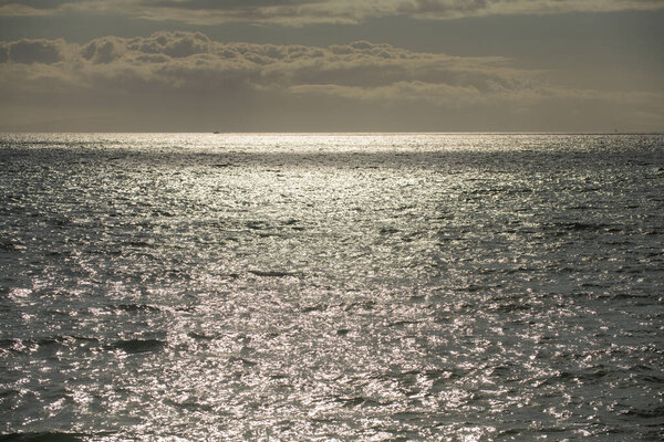 Спокойная текстура поверхности морской воды с брызгами и волнами. Абстрактный природный фон. Фон поверхности аква-океанской воды