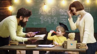 The family school. Happy family drawing book. Mother father and son reading the homework on book. Parents feeling proud on progress of child son