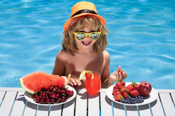 夏の果物 夏休みにはプールの近くで果物を食べる子供 子供は果物を食べる 子供のための健康的な果物 子供と夏休み ストロベリー スイカ チェリー ブルーベリー — ストック写真