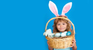 Kid boy with easter basket isolated on blue background. Happy Easter. Easter bunny children. Panoramic web banner frame