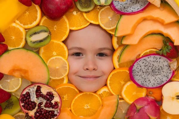 Vitamins from fruits. Mix of fruits near kids face. Assorted mix of summer fresh fruits. Healthy nutrition for kids