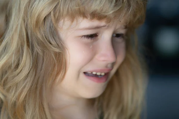 Kid crying with a tear on cheek. Child with sad expressions, crying. Sad kid crying