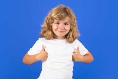 Child showing thumbs up on studio isolated background. Portrait of kid boy making thumbs up sign