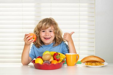 Kid eating apple. Child eats organic food. Healthy vegetables with vitamins. Proper kids nutrition concept