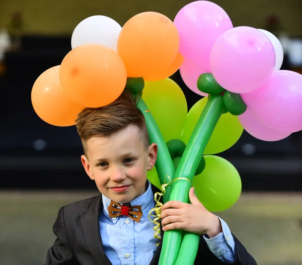 Schoolboy with bouquet of flowers and balloons. Goes to school on September 1. New academic year