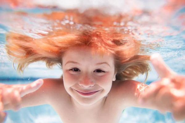 Funny kids face under water. Child swimming underwater in swimming pool. Funny kids face. Kids beach fun. Children swim in the sea water