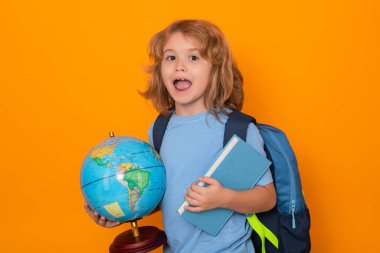 Isolated portrait of school child. School pupil with world globe and book. Little student learning, study geography or literature at school. Elementary school child