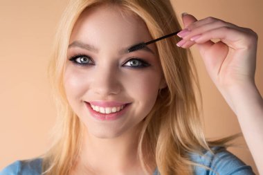 Beautiful woman with perfect shape eyebrows. Womans brows close up. Beautiful girl with eyebrow brush. Eyebrow correction. Long eyelashes and thick eyebrows