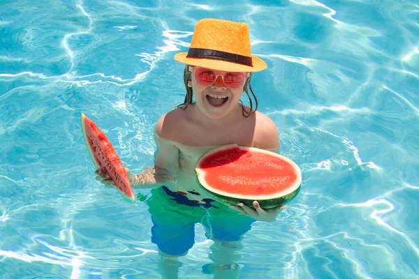 Child eat watermelon in the pool. Summer kids face