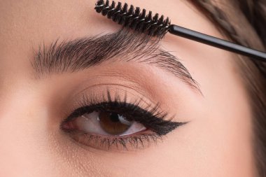 Closeup eyebrows with eyebrow brush. Close up brows, eyebrows lamination. Brow procedures. Long eyelashes, eyebrows, macro
