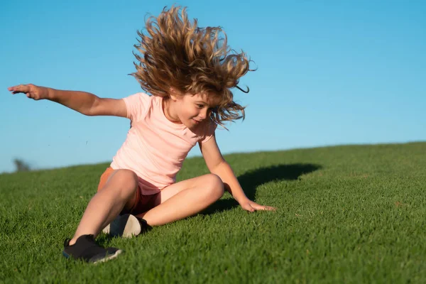 Kid falling down on the grass. Moment of the fall down. Little child tripped and falls down. Fall risk for children. The moment of the fall. Clumsy kid