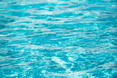 Su arka planı, dalgalanma dalgaları. Mavi yüzme havuzu deseni. Deniz yüzeyi. Yüzme havuzunda su ve güneş yansıması. Kopyalama alanı olan pankart