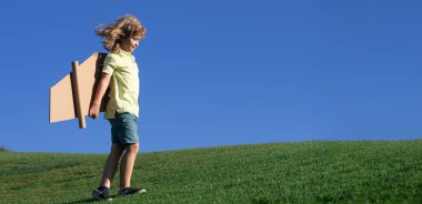 El yapımı el yapımı kağıt uçak kanatları olan çocuk pilotu. Çocuklar rüya görür, başarı, yaratıcı ve başlangıç konsepti. Bahar ve çocuk. Web sayfası başlığı için geniş resim pankartı