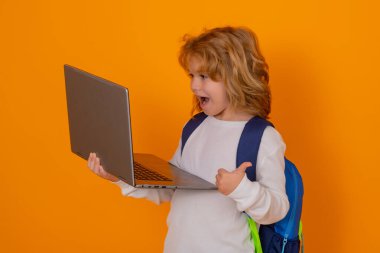 Okul çocuğunun izole edilmiş portresi. Dizüstü bilgisayar kullanan okul çocuğu. Stüdyoda izole edilmiş inek öğrenci. Bilgisayarlı ilkokuldan zeki bir çocuk.