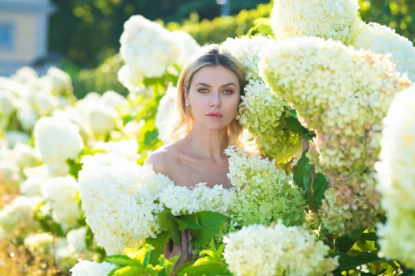 Sexy girl with summer makeup. Spring woman with hydrangea flowers. Summer beauty. Fashion portrait of woman. Healthy hair and skin. Spring mood