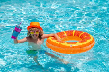 Kid boy relaxing in pool. Child swimming in water pool. Summer kids activity, watersports. Summer kids cocktail