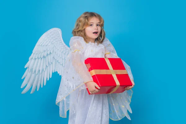 Cute child angel with gift box present. Beautiful little angel. Isolated studio shot. Cute Pretty child with angel wings. Cupid, valentines day concept