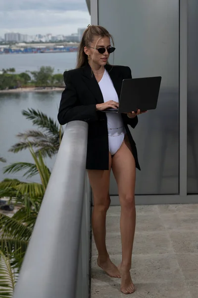 Sexy business woman. Beautiful secretary with laptop. Sexy businesswoman in a suit. tylish business woman on office balcony