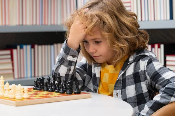 Play chess. Clever concentrated and thinking kid playing chess. Kids brain development and logic game