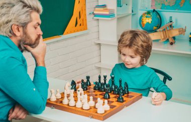 Babalar Günü. Satranç stratejisi geliştiren konsantre bir çocuk. Satranç oynarken akıllı konsantre ve düşünceli çocuk.