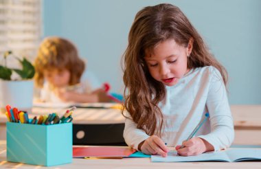 Çocuklar, okulda resim çizen tatlı bir kız.