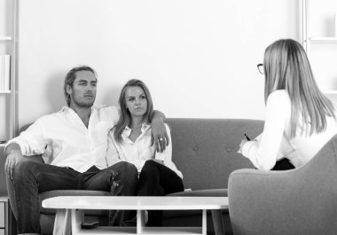 Aile içi sorunları sosyal hizmetler görevlisi ya da aile psikologu ile tartışan bir çift. Aile psikoloji oturumunda