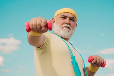 Kıdemli sportmen halter kaldırıyor. Yaşlı adam egzersiz