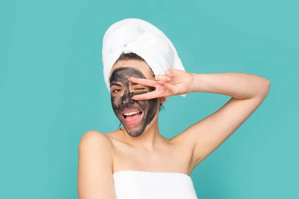 Facial charcoal mask. Cosmetics, cosmetology, dermatology. Woman face with black clay mask. Cosmetic procedure womans face in the mask on face