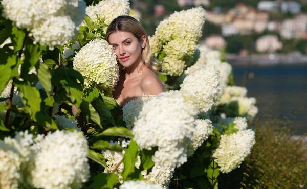 Sexy girl with summer makeup. Spring woman with hydrangea flowers. Summer beauty. Fashion portrait of woman. Healthy hair and skin. Spring mood