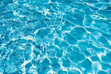 Su arka planı, dalgalanma dalgaları. Mavi yüzme havuzu deseni. Deniz yüzeyi. Yüzme havuzunda su ve güneş yansıması. Kopyalama alanı olan pankart