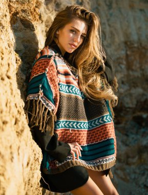 Boho tarzı süveter giyen güzel bir kadın. Moda kadını dışarıda poz veriyor. Seksi elbiseli çekici genç kadın yazın tadını çıkarıyor.