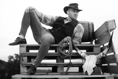 Erkek kovboy. Çiftliğin sahibi. Çiftlik işçisi ve tarım kavramı. Kovboy şapkalı ve köylü tarzı kıyafetli yakışıklı bir adam. Erkekler eski moda, eski moda, vahşi erkek model.